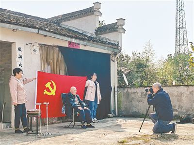 图②：倪国初（右一）为百岁老兵汪治华拍照。黄亚明摄