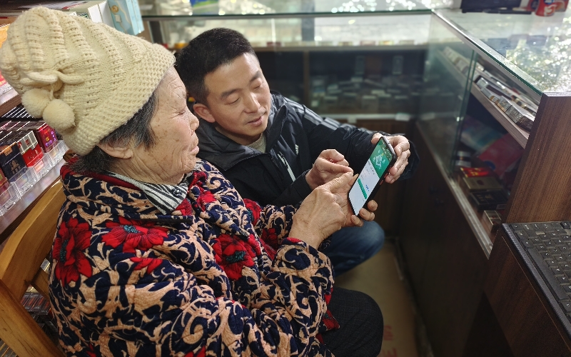 客户经理潘磊指导零售户使用全国统一卷烟订货平台微信端小程序订货。