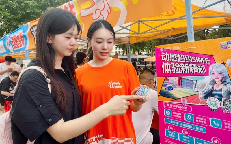 工作人员向学生介绍AI算力卡等科技创新产品。