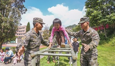 佳克学校学生在武警官兵的保护下，开展军事项目体验。李梓良摄