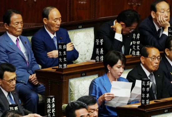 　　10月21日，在日本东京，自民党总裁高市早苗（前排右二）在临时国会众议院首相指名选举现场阅读文件。新华社记者贾浩成摄