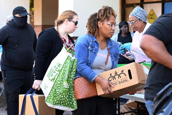 10月21日,在美国马里兰州海厄茨维尔市,联邦雇员领取免费食品。新华社记者李睿摄