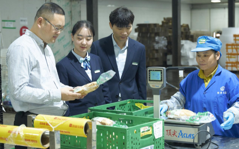 邮储银行工作人员在农业项目现场。