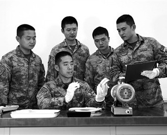 火箭军某旅某营高级技师、一级军士长毛伟(左二)正向班组战友讲解装备组件原理。本报特约通讯员 李 昌摄