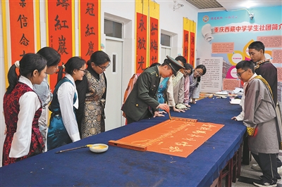 11月6日，信息支援部队工程大学通信士官学校“红岩雪鹰”宣传队队员在重庆西藏中学宣讲后，与师生一起参与学校书法社团活动。 谌世鑫摄