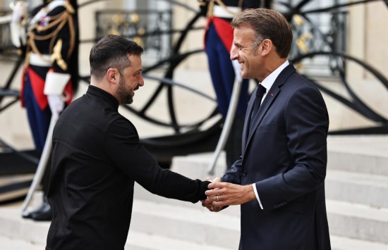 2025年9月4日,在法国首都巴黎的总统府爱丽舍宫,法国总统马克龙(右)迎接出席“志愿联盟”线上会议的乌克兰总统泽连斯基。新华社记者高静摄