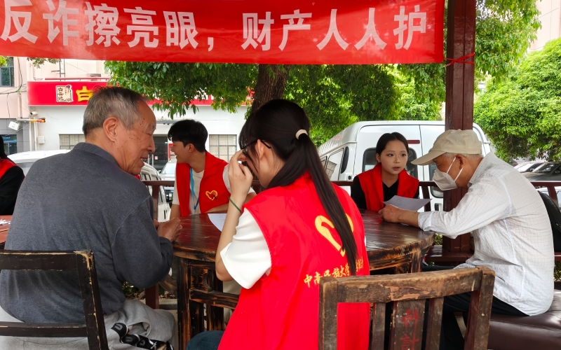 青年志愿者为社区居民一对一普法。学校供图